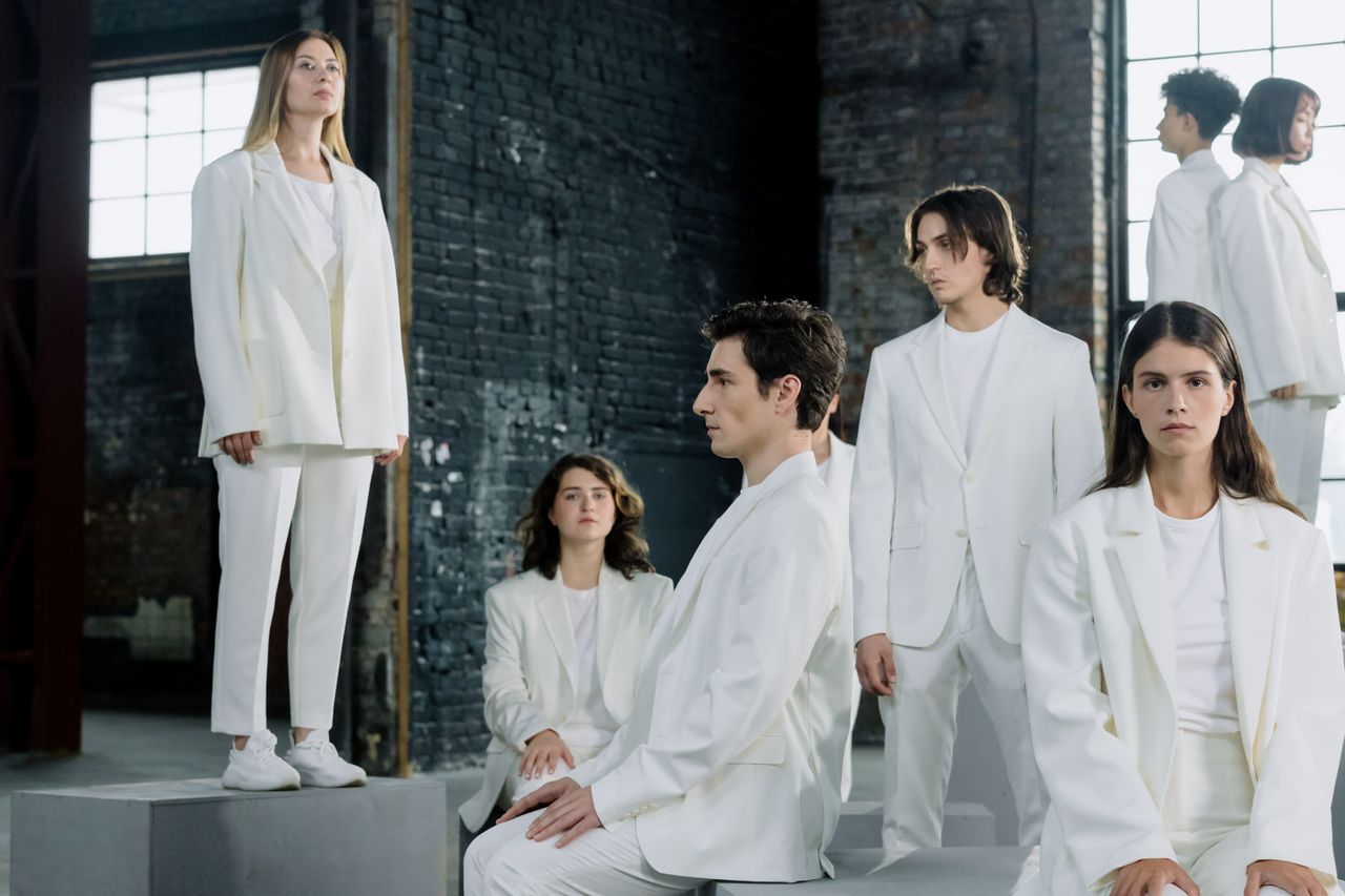 Mastering the First Impression: Your intriguing post title goes here Stylish group fashion photo with models in white suits in an industrial setting.