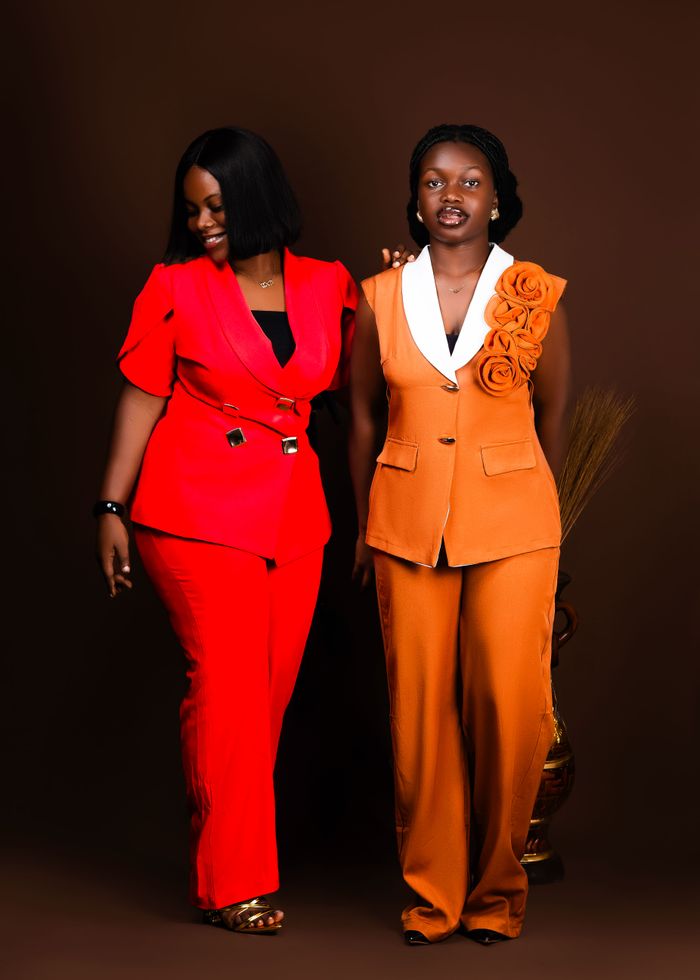 The Art of Drawing Readers In: Your attractive post title goes here Two women in red and orange suits pose confidently against a brown studio backdrop.